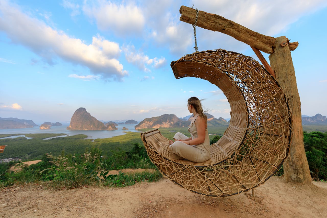 about-01 Woman in rattan hammock enjoying Phang-nga Bays scenic view at sunset.